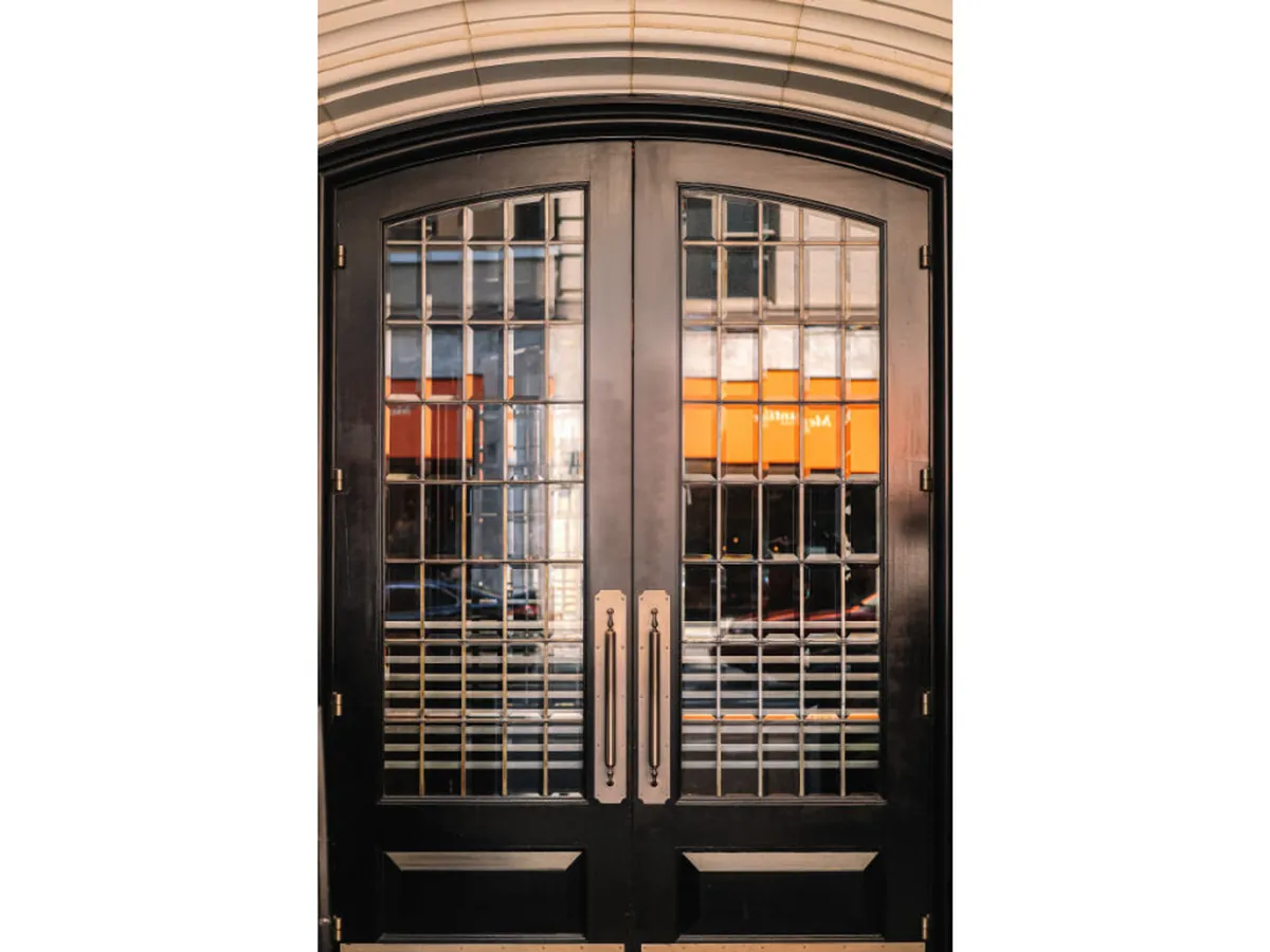 A close-up of double glass doors with decorative handles marks the threshold from the outside world to the hotel’s welcoming lobby or gathering space. The emphasis on wide, unobstructed doors suggests step-free access.